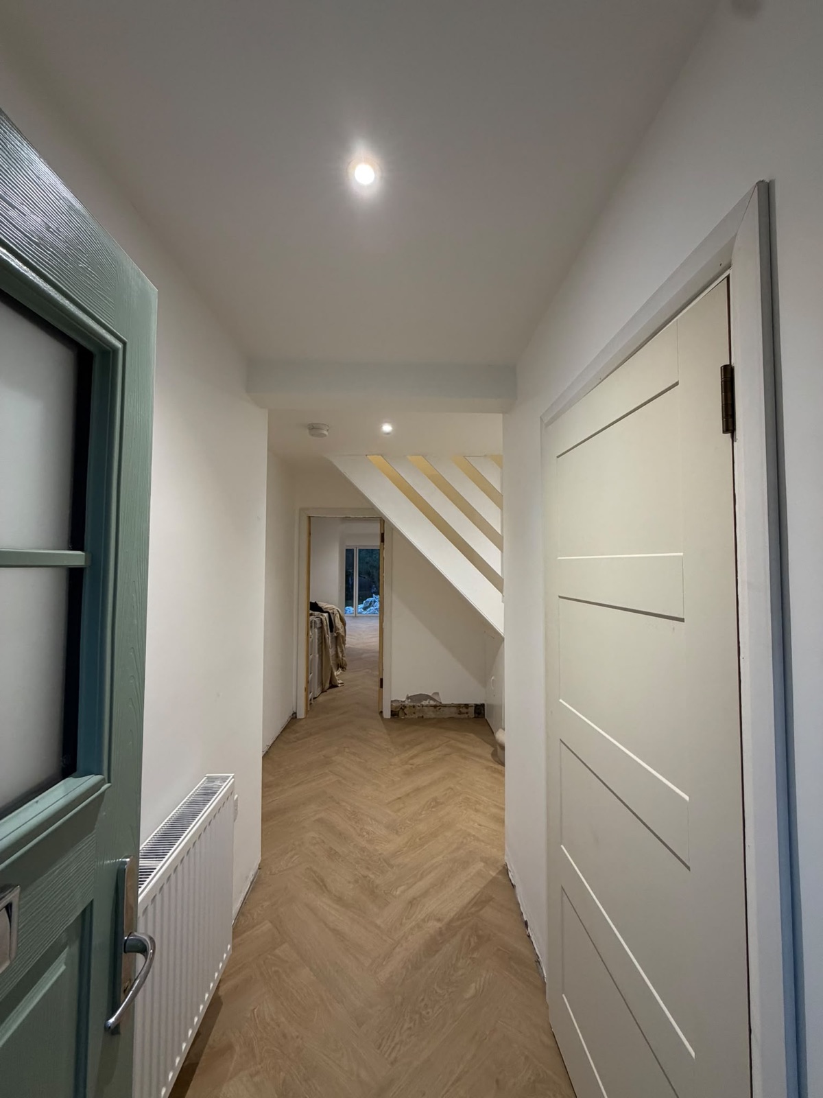 Hallway with recessed downlights and herringbone flooring